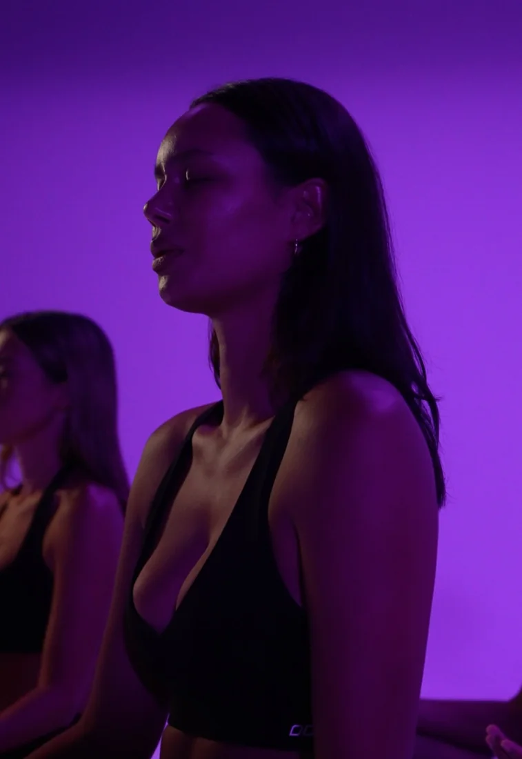 A woman breathing deeply in violet light